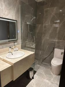 a bathroom with a sink and a shower and a toilet at بياسة للاجنحة الفندقية in Riyadh