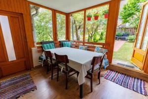 een eetkamer met een tafel, stoelen en ramen bij Casa Sighisoara56 in Sighişoara