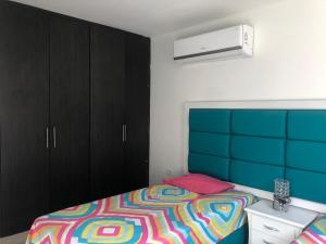 um quarto com uma cama com um cobertor colorido em Casa Esquina Condominio Diomedes Daza Valledupar em Valledupar