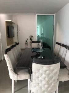 uma sala de jantar com uma mesa com cadeiras e uma mesa; em Casa Esquina Condominio Diomedes Daza Valledupar em Valledupar
