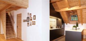 una cocina con techos de madera y una escalera en una habitación en Halbwöhrerhof, en Anterselva di Mezzo