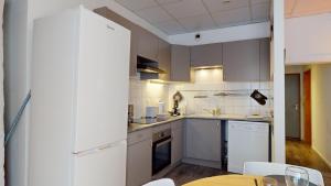a kitchen with white cabinets and a table at Appartement Le Key6 in Sélestat