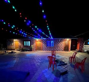 马迪凯里cocostay coorg的晚上，一组红色的椅子摆放在露台上