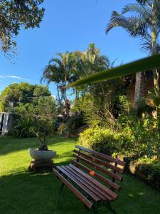 un banc de parc assis dans l'herbe près d'une cour dans l'établissement Chalé Céu estrelado, à Caruaru