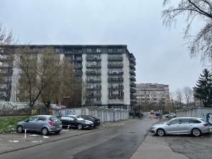 un parking avec des voitures garées devant un bâtiment dans l'établissement Apartament Zlota Jesień 2C, à Cracovie