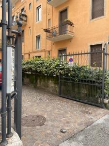 uma cerca em frente a um edifício com plantas em Appartamento a pochi passi dal Duomo em Trento