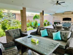 un patio con sofá, mesa y sillas en Luxury villa with Pool and Jacuzzi, en Ereván