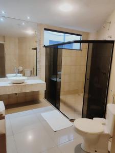 a bathroom with a toilet and a sink and a shower at Hotel Veneza in Itabuna