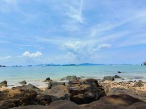 瑤亞島的住宿－Sunrise Beach Kohyao Resort，阴天有岩石和海洋的海滩