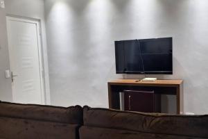 a living room with a couch and a flat screen tv at Casa Temporada Terra Nova in Uberaba