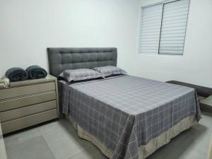 a bedroom with a bed and a dresser and a window at Casa Temporada Terra Nova in Uberaba
