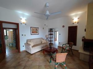 een woonkamer met een bank en een tafel bij Villa Torre San Giovanni Lido Sabbioso 151-Verso Sud in Torre San Giovanni Ugento