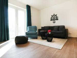 uma sala de estar com um sofá e uma cadeira em Hafenspitze App 05 em Wismar