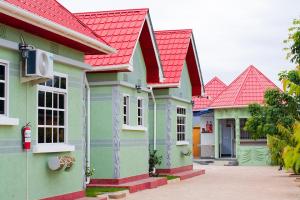 a row of colorful houses with red roofs at Kigongoni Gazella Hotel in Mto wa Mbu