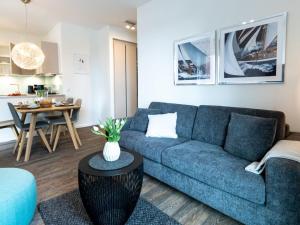 ein Wohnzimmer mit einem blauen Sofa und einem Tisch in der Unterkunft Hafenspitze App 22 in Wismar