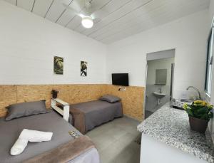 a bedroom with two beds and a sink in it at Vila 50 Hospedagem in Sao Paulo