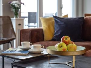 a coffee table with a plate of apples on a table at Hafenspitze App 37 in Wismar