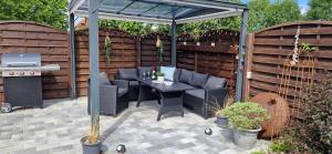 a gazebo with a table and a grill at Haus Veronika in Fehmarn +23 photos