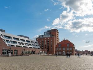 a city square with buildings and people walking around at Hafenspitze App 37 in Wismar