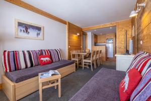 uma sala de estar com um sofá e uma mesa em Résidence Pierre & Vacances Les Néréides em Belle Plagne