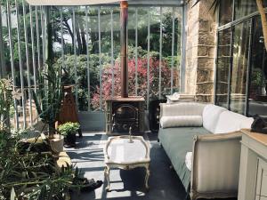 a conservatory with a couch and a wood stove at La Pluie de Roses in Giverny