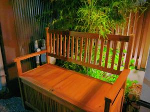 una panchina di legno seduta di fronte a una pianta di suikakan heianjingumae 酔花間 a Kyoto