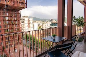 a balcony with a table and chairs and a view of a city at ProGarden Luxury Apartments Tirana in Tirana