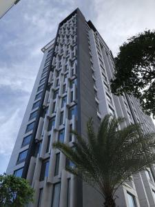 een hoog gebouw met een palmboom ervoor bij Louisa Vinh Hoi Apartment in Ho Chi Minh-stad