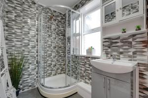 ein Bad mit einer Dusche und einem Waschbecken in der Unterkunft Spacious and perfectly located 4-bedroom Apartment in Liverpool