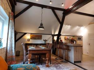 a dining room with a table and a kitchen at Ferienhaus Alte Schmiede - weites Land in Lutherstadt Wittenberg