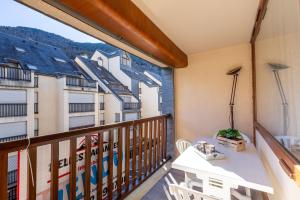 a balcony with a table and a view of buildings at Bel Appt Plein Coeur de Saint Lary Soulan in Saint-Lary-Soulan