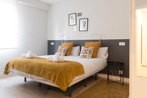 una camera da letto con un grande letto con cuscini arancioni e bianchi di BILBAO ARGIA a Bilbao