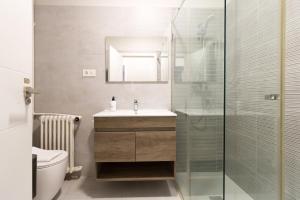 a bathroom with a sink and a glass shower at BILBAO ARGIA in Bilbao