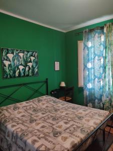 a bedroom with a bed with a green wall at Night & Day Affittacamere di Laura Patuelli in Cotignola