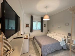 a bedroom with a large bed and a television at SoleeMare Barletta in Barletta