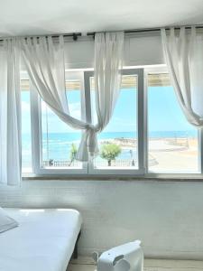 a bedroom with a window with a view of the beach at SUNSET LOFT in Livorno