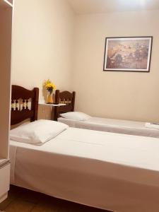 um quarto com duas camas e uma foto na parede em Pousada Castanheira em Guarapari