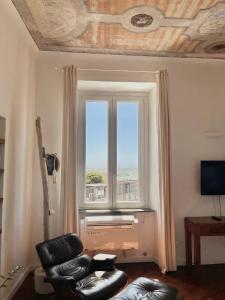 uma sala de estar com uma cadeira e uma janela em THE SUNSHINE LOFT em Livorno