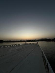 a bridge over a body of water at sunset at A private tour of the Nile to watch the sunset by boat and then to Banana Island in Al Karnak