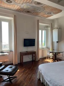 um quarto com uma cama e uma televisão de ecrã plano em THE SUNSHINE LOFT em Livorno