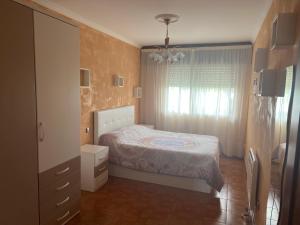 a small bedroom with a bed and a dresser at Apartamento Naron in Narón