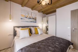 Un dormitorio con una cama grande con almohadas amarillas y blancas. en Royal Blue Marine, en Vodice