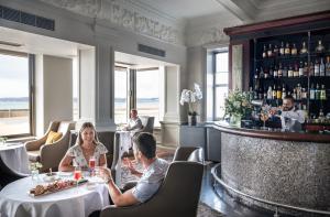 un grupo de personas sentadas en una mesa en un restaurante en Grand Jersey Hotel and Spa en Saint Helier