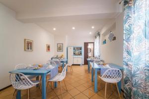 a dining room with blue tables and white chairs at AGROLEA Hotel Ristorante in Terme Vigliatore