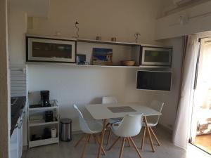 a kitchen with a white table and chairs and a counter at Appartement climatisé à 800m de la plage in Fréjus +12 photos