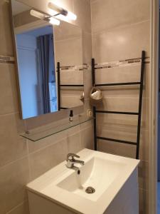 a bathroom with a white sink and a mirror at Appartement climatisé à 800m de la plage in Fréjus