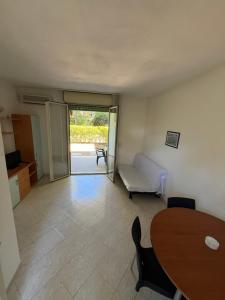 ein Wohnzimmer mit einem Tisch und einem Sofa in der Unterkunft Residence Verde Pineta in Principina a Mare
