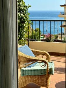 una sedia in vimini su un balcone con vista sull'oceano di Can Luc Altea ad Altea