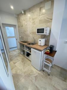 uma pequena cozinha com um lavatório e um micro-ondas em Estudio Conil Playa em Conil de la Frontera