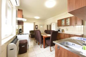 a kitchen and living room with a table and a dining room at Milán Apartment in Nyíregyháza